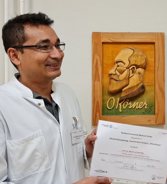 Arzt mit Brille und Zertifikat in der Hand, HNO-Klinik der Unimedizin Rostock 